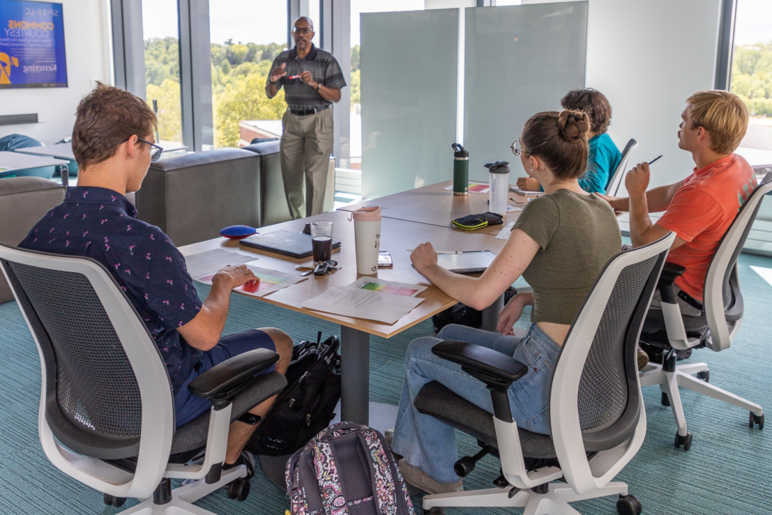 A Professor teaching a class of students in the Learning Commons